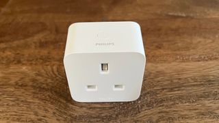 The top view of the Philips Hue smart plug on a wooden countertop