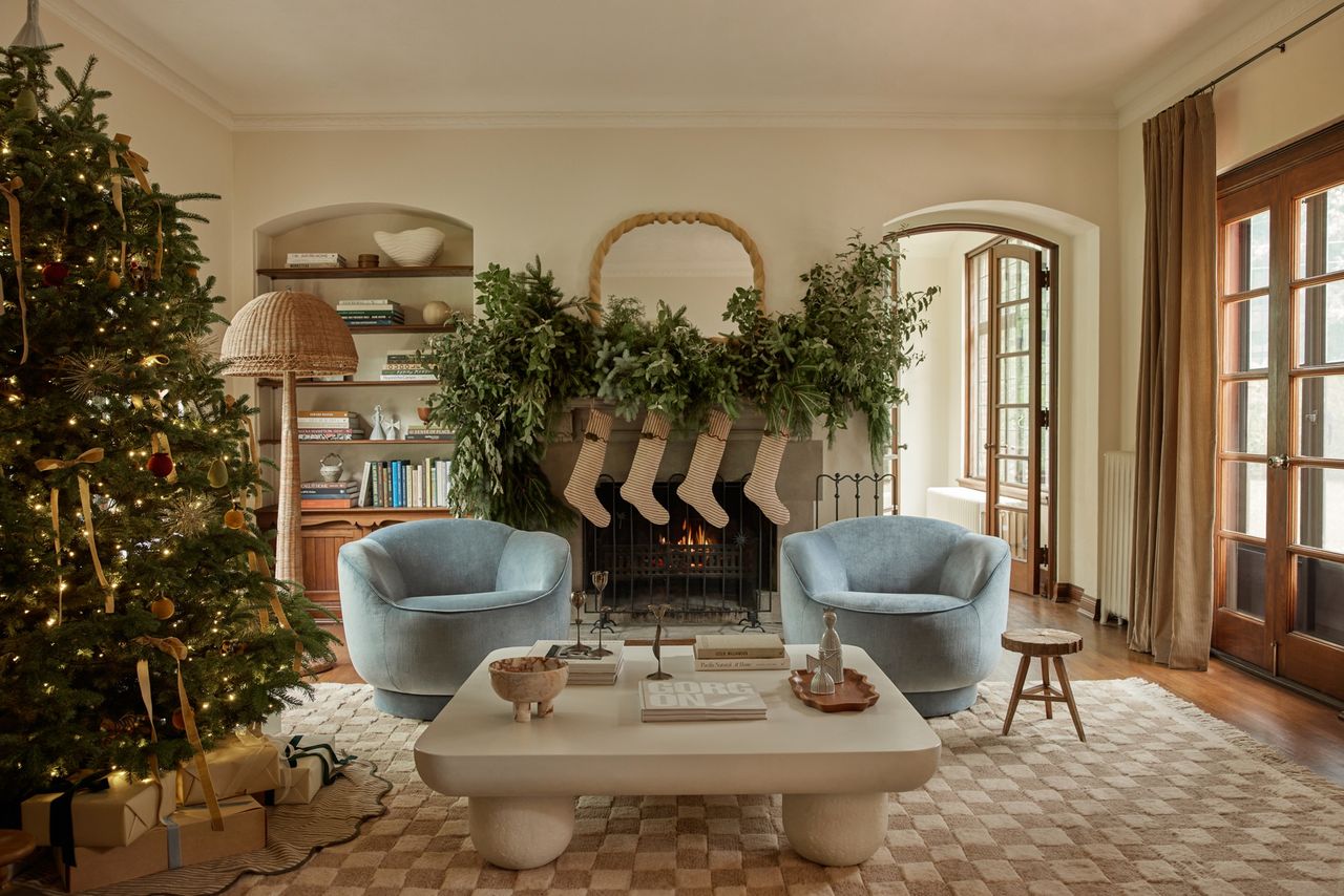 a living room with a christmas tree and large mantel garland