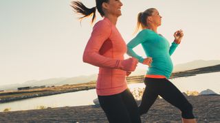 Female runners on a trail at sunset