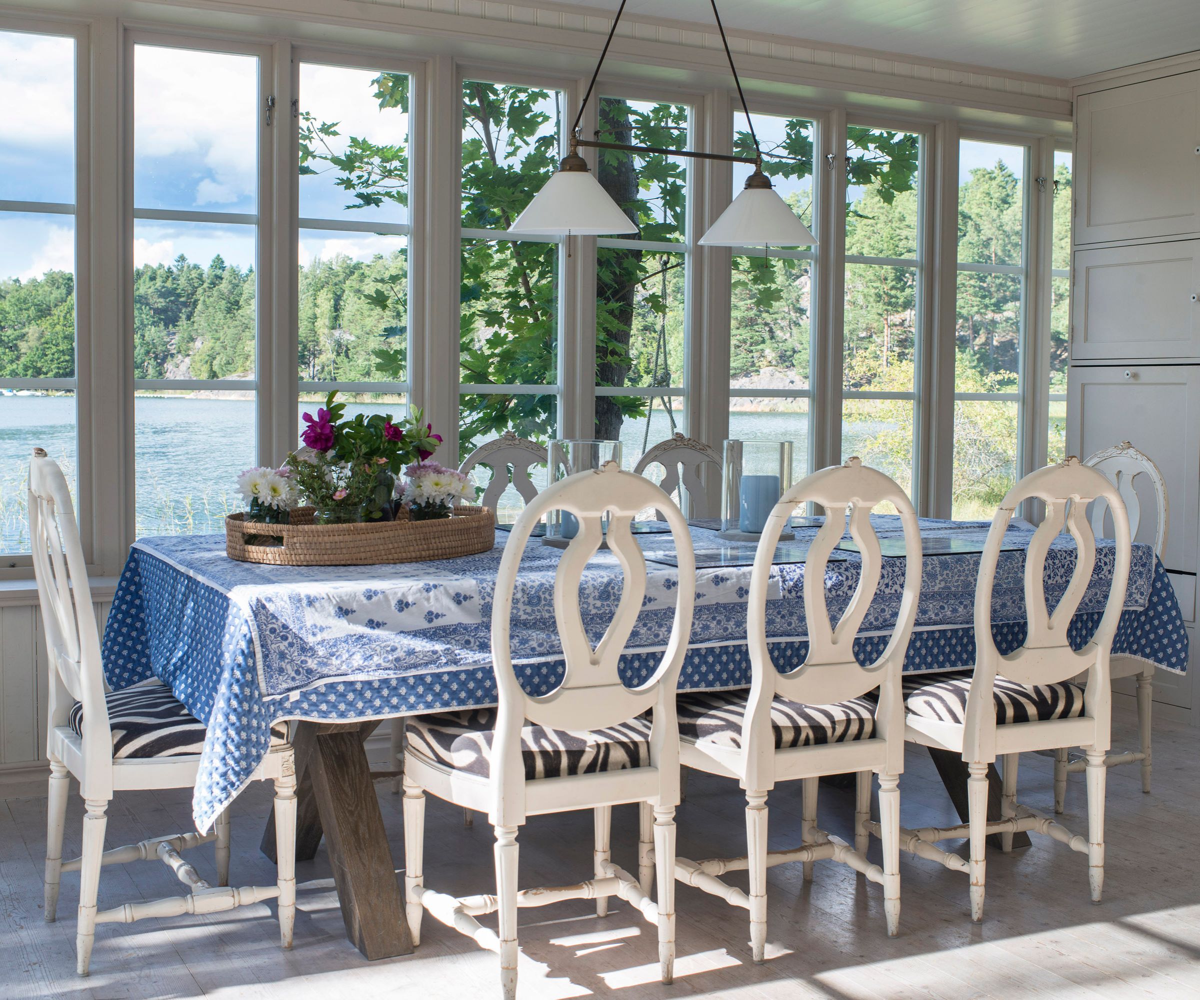 dining table with white chairs and waterside view