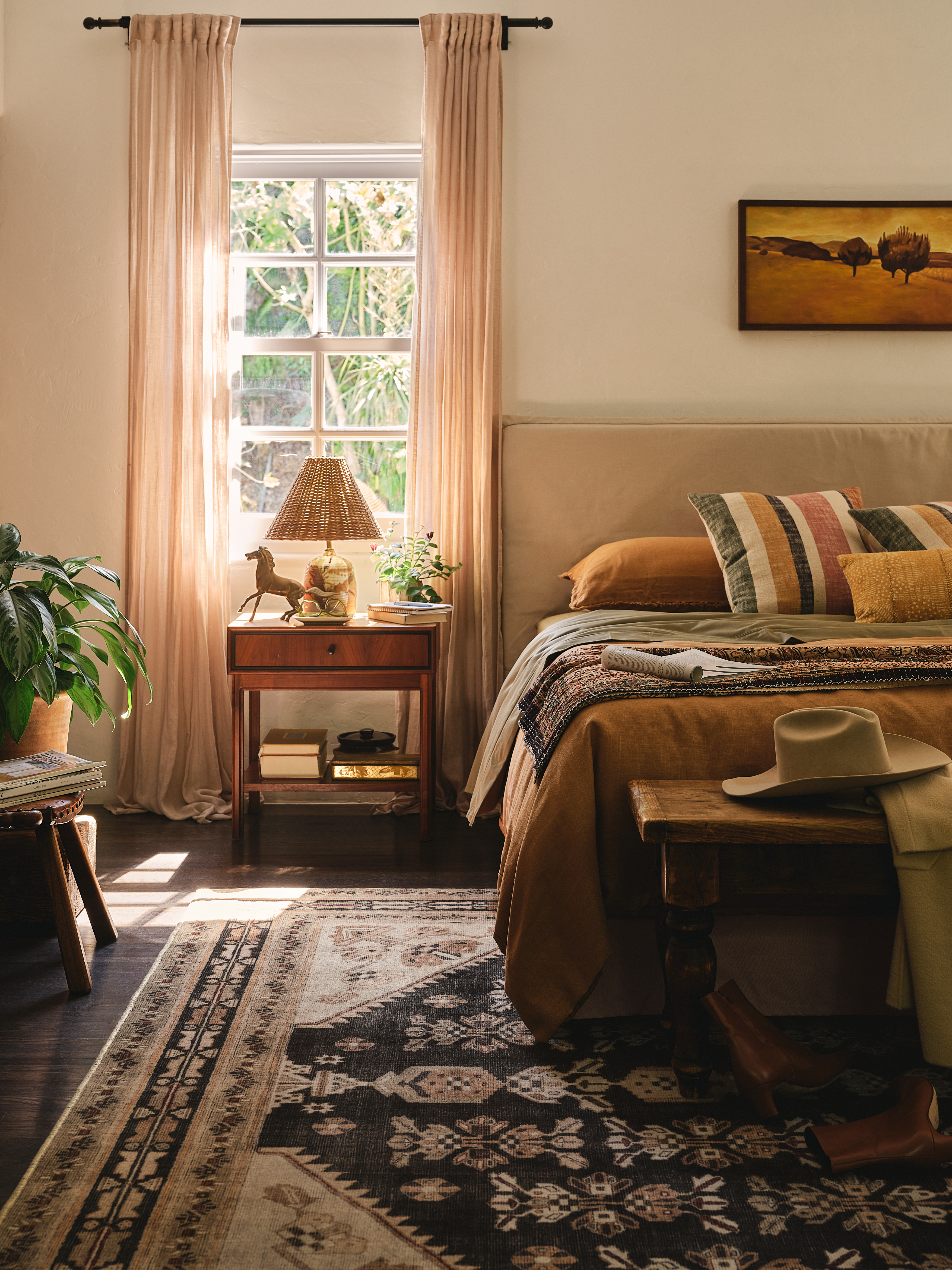 Bedroom design with dark wood floor and dark toned rug with light curtains