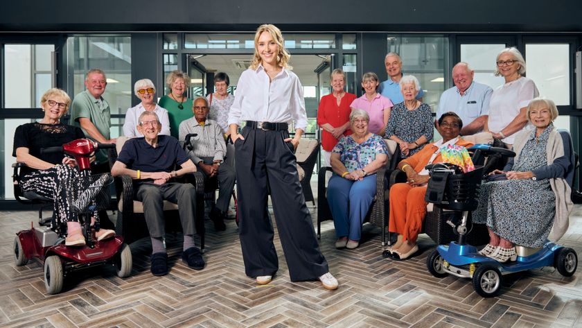 Rose in a while shirt and standing with her hands in her trouser pockets as she smiles for the camera. Behind her are Heather Green, Keith Wallis, Eric Fuller, Sue Egleton, Sally Hall, Abbas, Fiona Lafrate, Rose Ayling-Ellis, Karen Hopkins, Tina Jeffrey, Pam Cole, Mark Jeffrey, Trish, Mildred Carr, George Gatcum, Bev Snodgrass and Jan Rushton