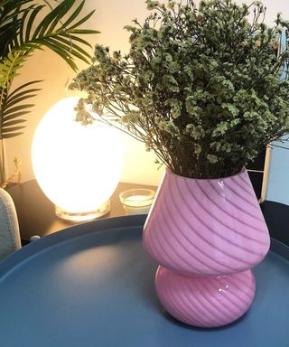 A table lamp next to a vase of flowers