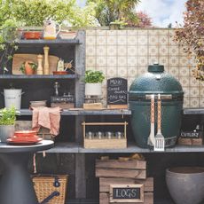 Outdoor kitchen with an egg BBQ and cooking equipment on it