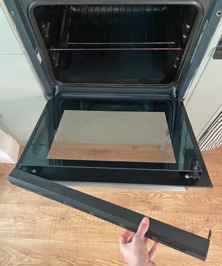 Oven door being removed in kitchen for cleaning