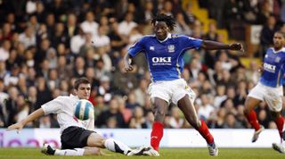 Portsmouth's Benjani Mwaruwari (C) takes a shot at goal past a tackle from Fulham's Aaron Hughes (L) during the Premiership football match at Craven Cottage in London 07 October 2007. Portsmouth won the game 2-0.