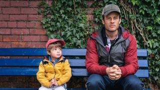 Bästa Viaplay-filmer: John sitter bredvid sin son Michael på en blå bänk i filmen Alltid nära dig.
