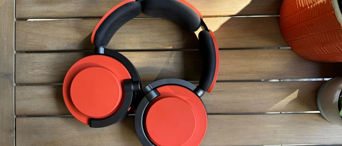 Dyson OnTrac headphones in Ceramic Cinnabar colour on wooden table