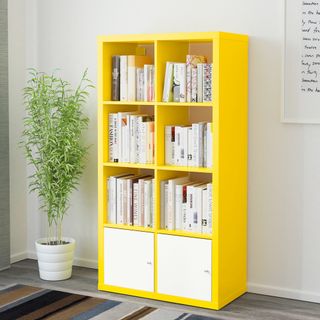 yellow book shelf with white walls and potted plants