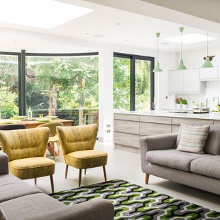 the living area has glass panel wall and gray sofa