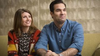 Rob and Sharon sit on a sofa together in Catastrophe