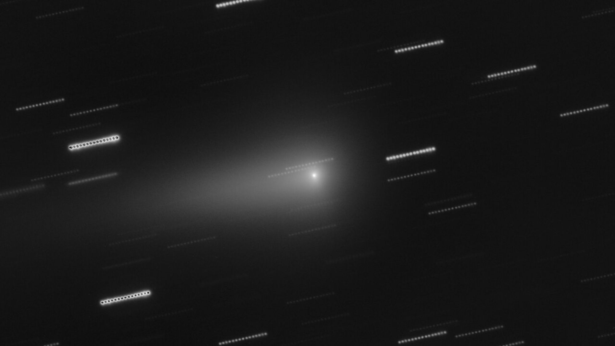 A black and white image with white streaks on it. In the middle, a glowing white dot.