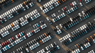 Aerial view of rows of parked new cars at an automotive plant