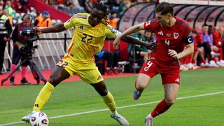 Jeremy Doku, of Belgium, and Wales' Ben Davies fight for the ball in a World Cup 2026 qualifier