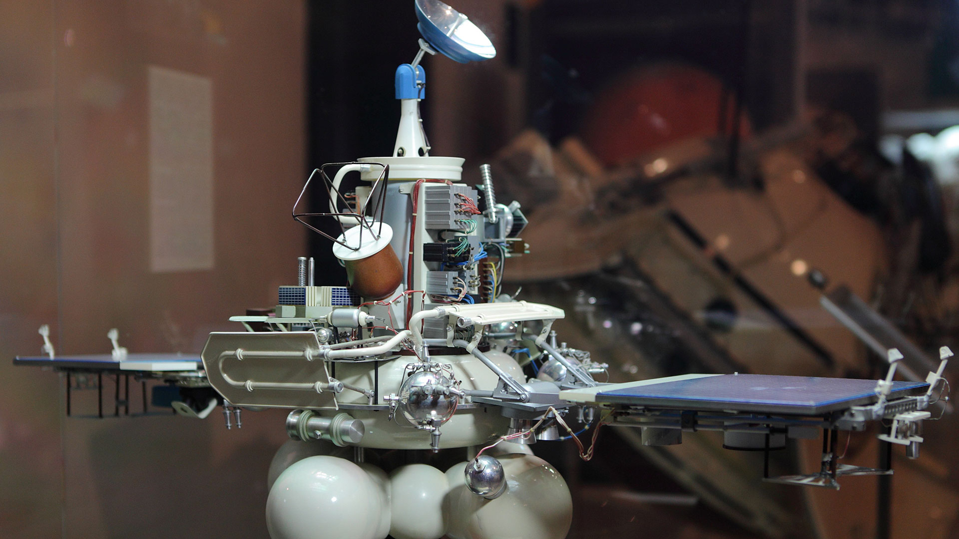 a scale model of a robotic planetary probe with solar panels, antenna, science instruments and propellant tanks.