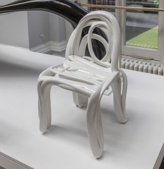 A white chair by front made with a process whose result resembles a wriggly hand sketch
