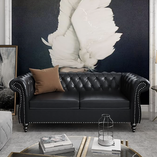Compact black faux leather tufted chesterfield couch.
