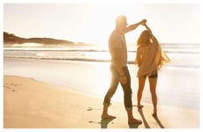 A couple dancing on the beach at sunset, symbolizing healing and connection in relationships.