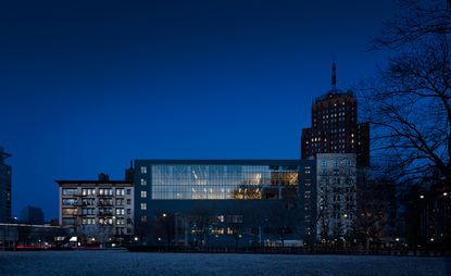 Blue building with glass-fronted section, photographed at night