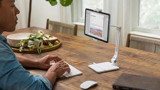 A man uses one of the best iPad stands, the Twelve South HoverBar Duo