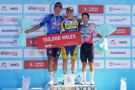 Sente Sentjens, Tom Crabbe and Cesar Mucias stand on the podium smiling and holding flowers at the finish of a stage of the Tour of Turkey