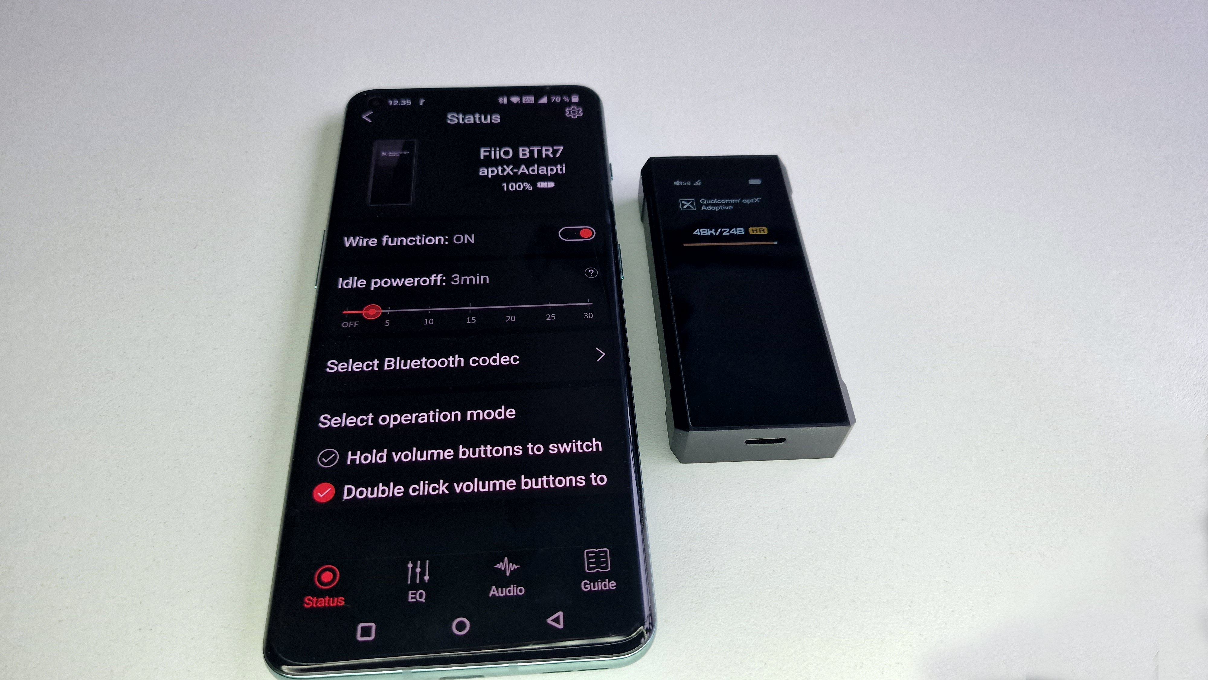 BTR7 ligger ved siden af telefonen, hvor BTR7-app'en er åben.
