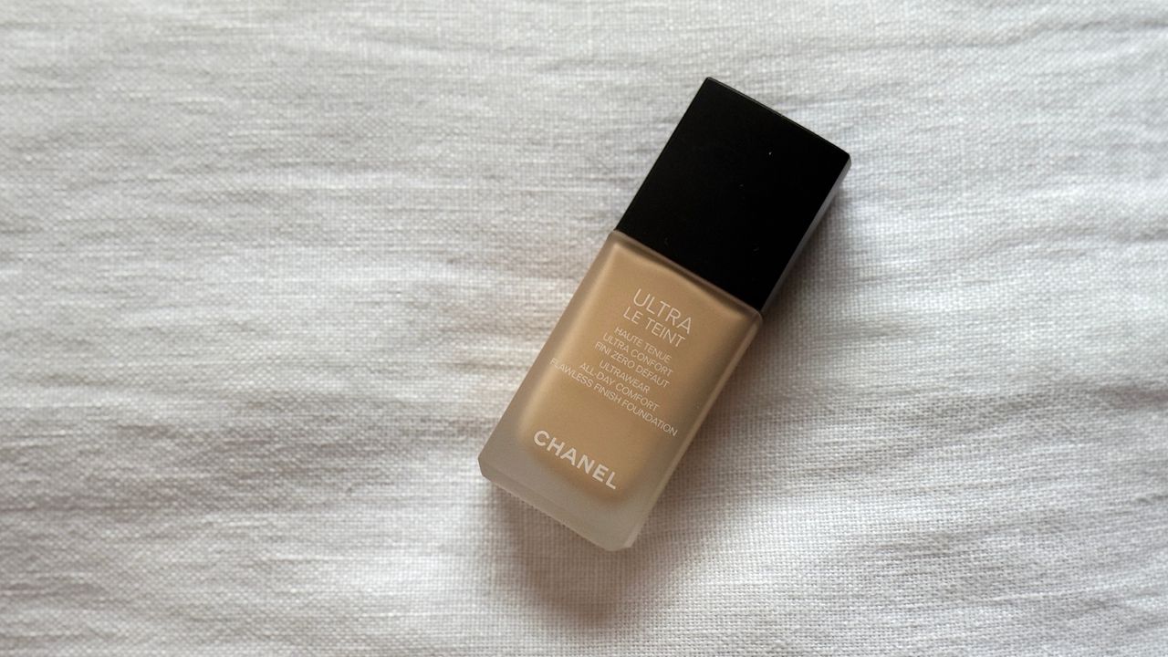 An original image of the Chanel Ultra Le Teint Foundation laying on a white linen background