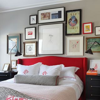 bedroom with photoframe on wall and red bed with pillows