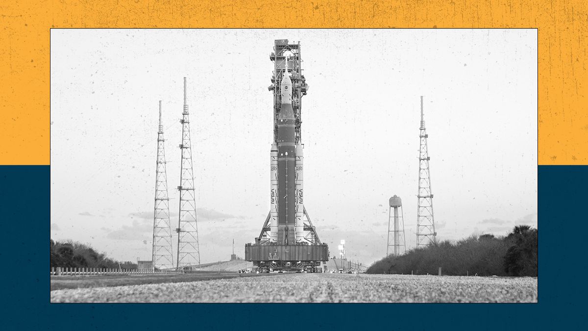 NASA's Artemis II rocket rolls along a gravel track.