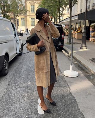  @sylviemus_ wearing suede coat, gray skirt, and leather mules.