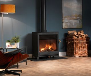 large freestanding log burner with large glass frontage in living room