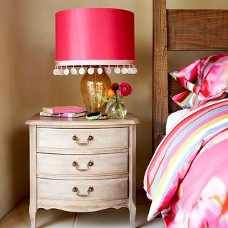 pom pom lamp vintage style chest of drawers and pink striped bed linen