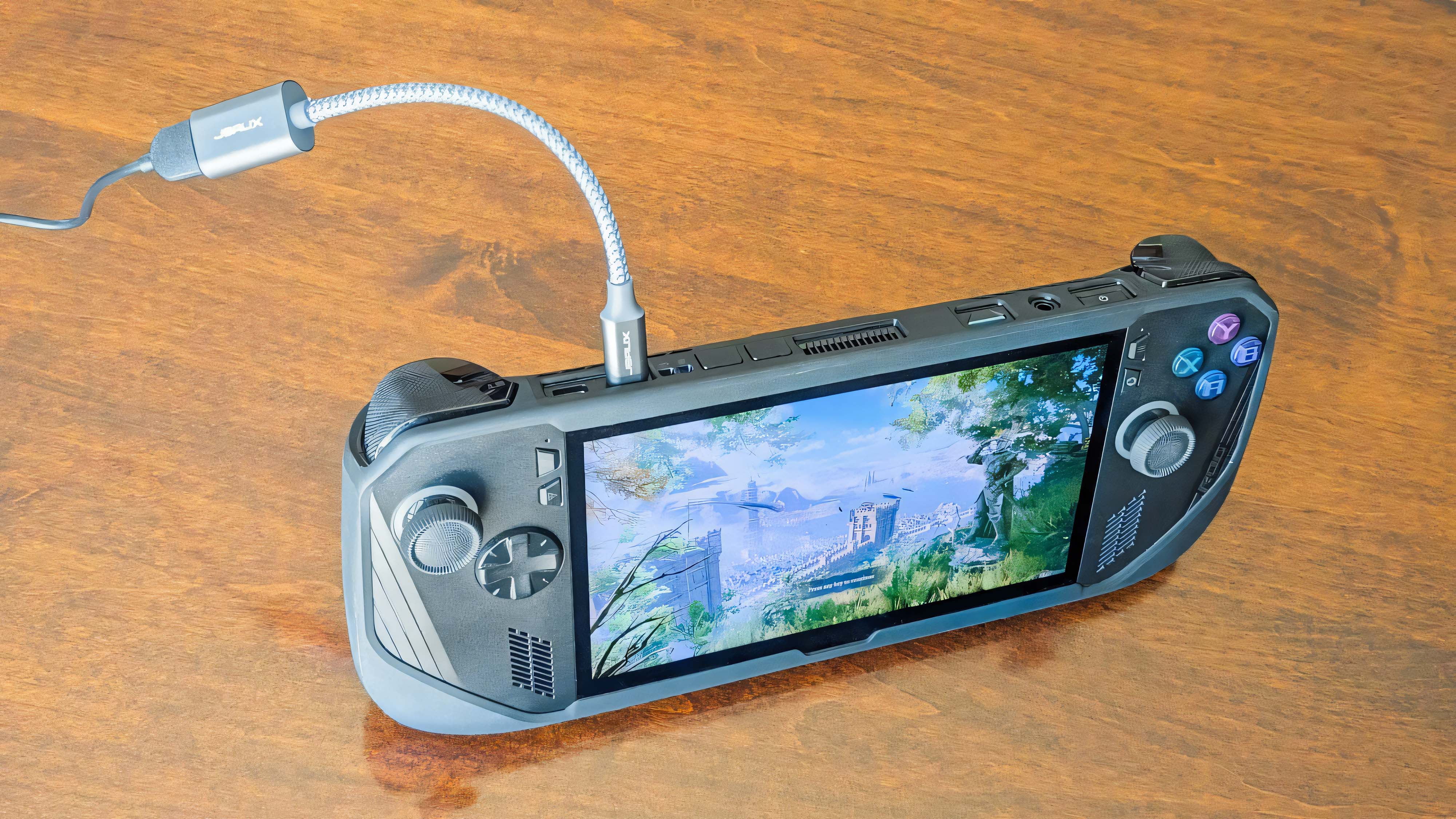 A JSAUX USB-C to USB-A braided adapter coming out of the top of an ROG Ally X and plugged into a USB-C cable.