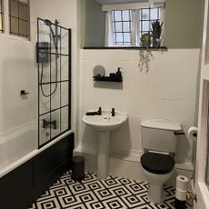 monochrome bathroom with patterned floor and black shower screen