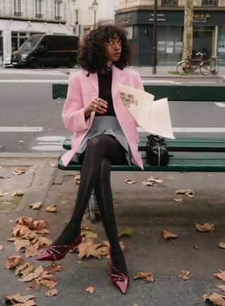 Emmanuelle Koffi wears a pink blazer and burgandy mules