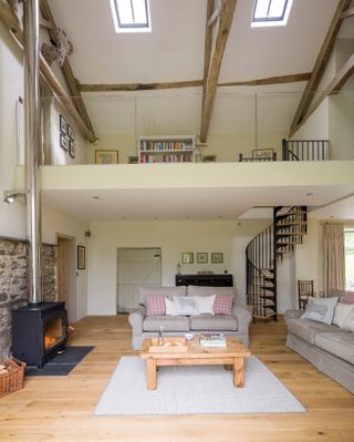 mezzanine house with living room, staircase, sofa and wood burning stove