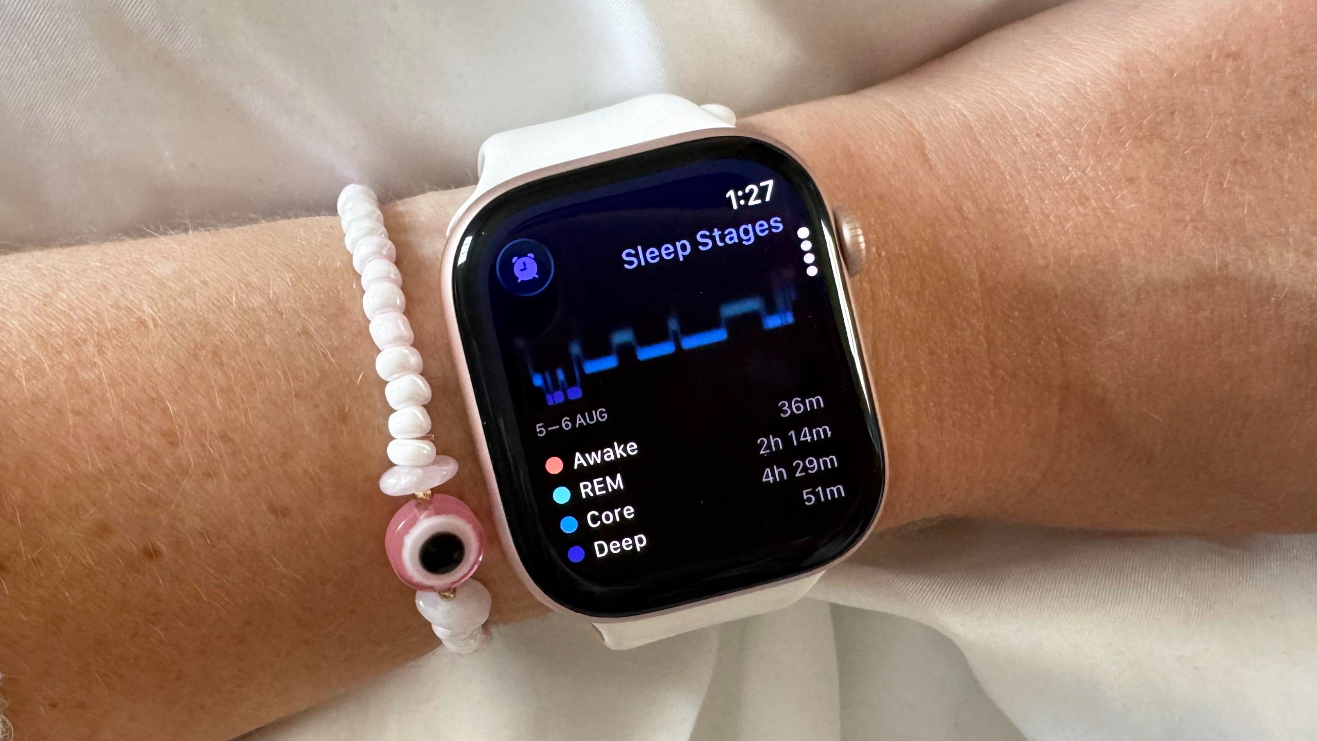Close-up of the Apple Watch 12 on a user's wrist with a recent sleep report shown on the screen