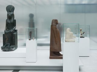 Egyptian figurines displayed on white plinths