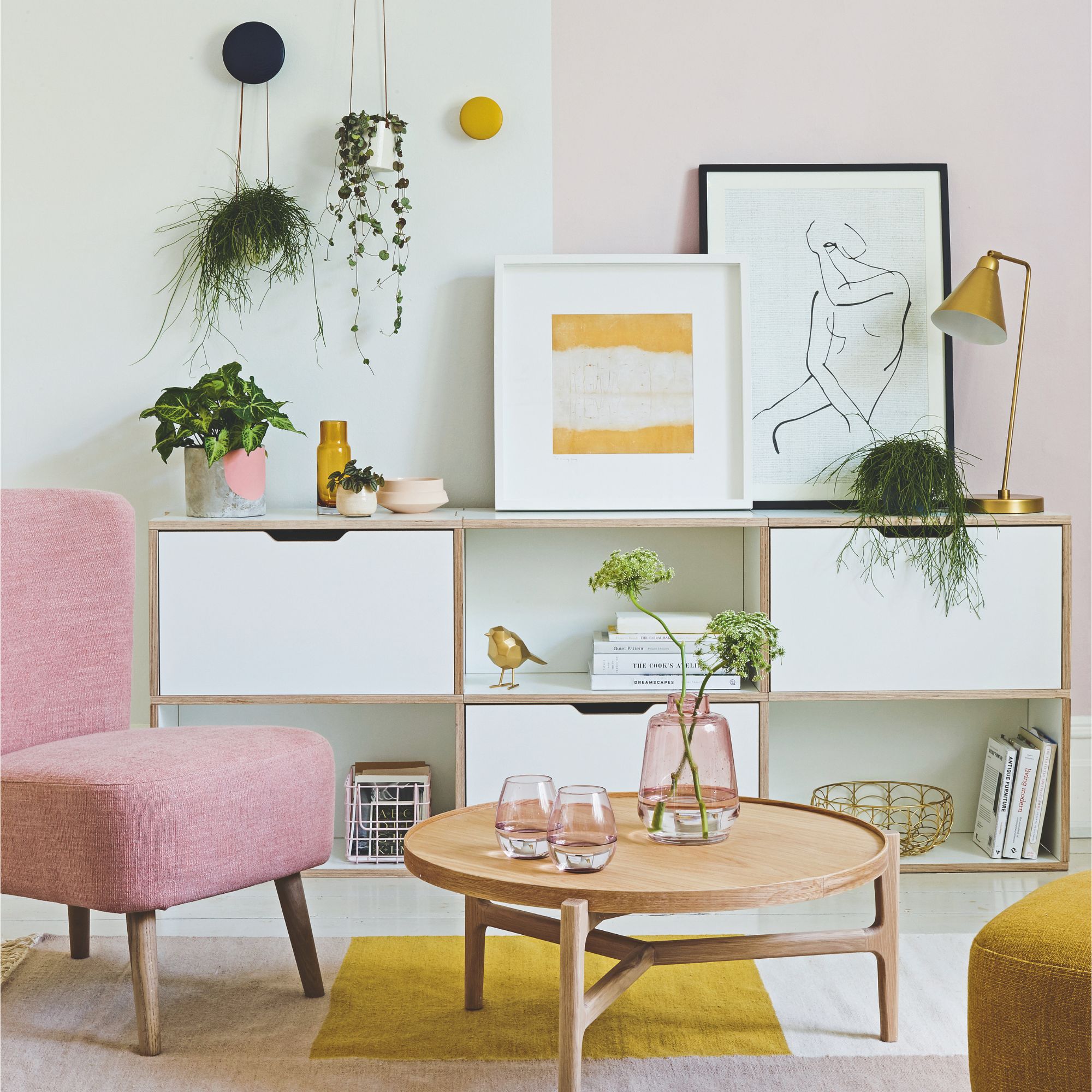 A white, yellow and pink living room scheme with houseplants and flowers