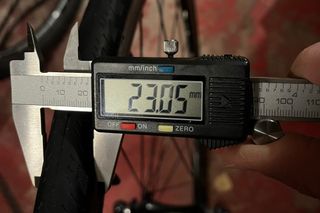 Taking a digital calliper measurement which reads 23.05mm of the Brand X Road Bike Kenda tyre