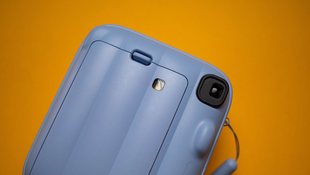 Fujifilm Instax Mini 13 instant camera against a yellow colored sheet