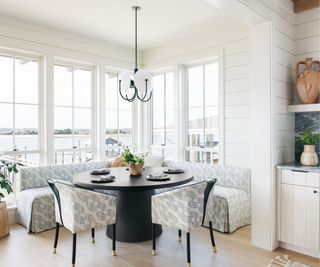 White wooden walls, black round dining table
