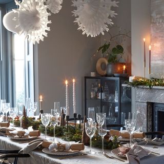 Dining room with decorated tablescape and hanging paper Christmas decorations