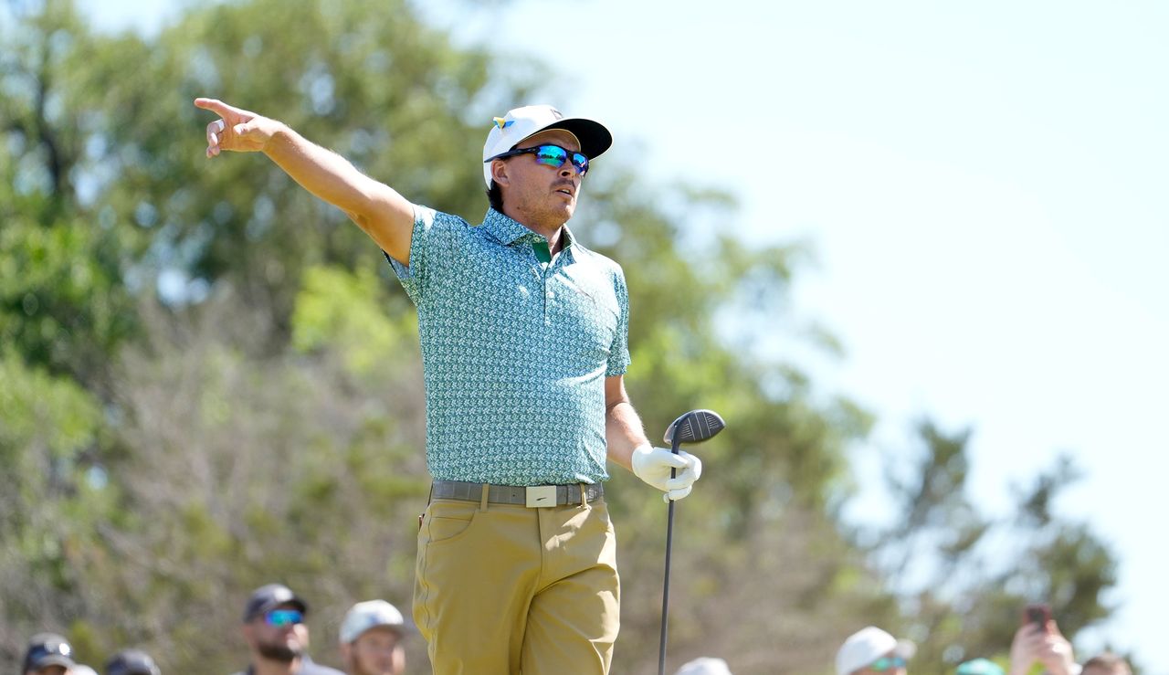 Rickie Fowler points to the right after hitting his tee shot