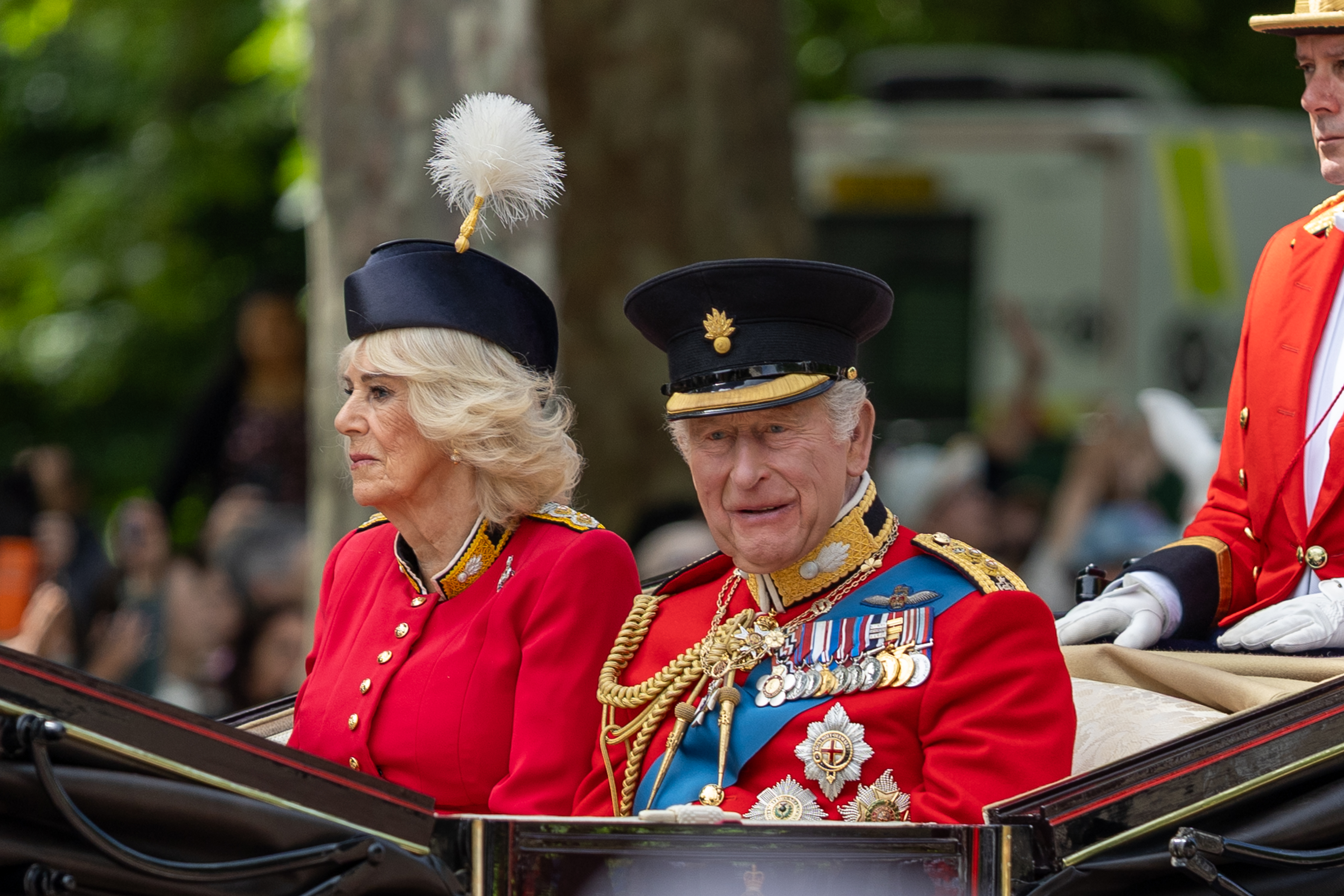 King Charles and Queen Camilla riding in a carriage