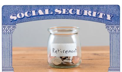 US coins inside a glass jar that reads &quot;Retirement,&quot; surrounded by a Social Security Card