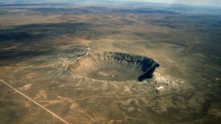 Meteor Crater in Winslow, Arizona. A massive crater can be seen among flat high desert.