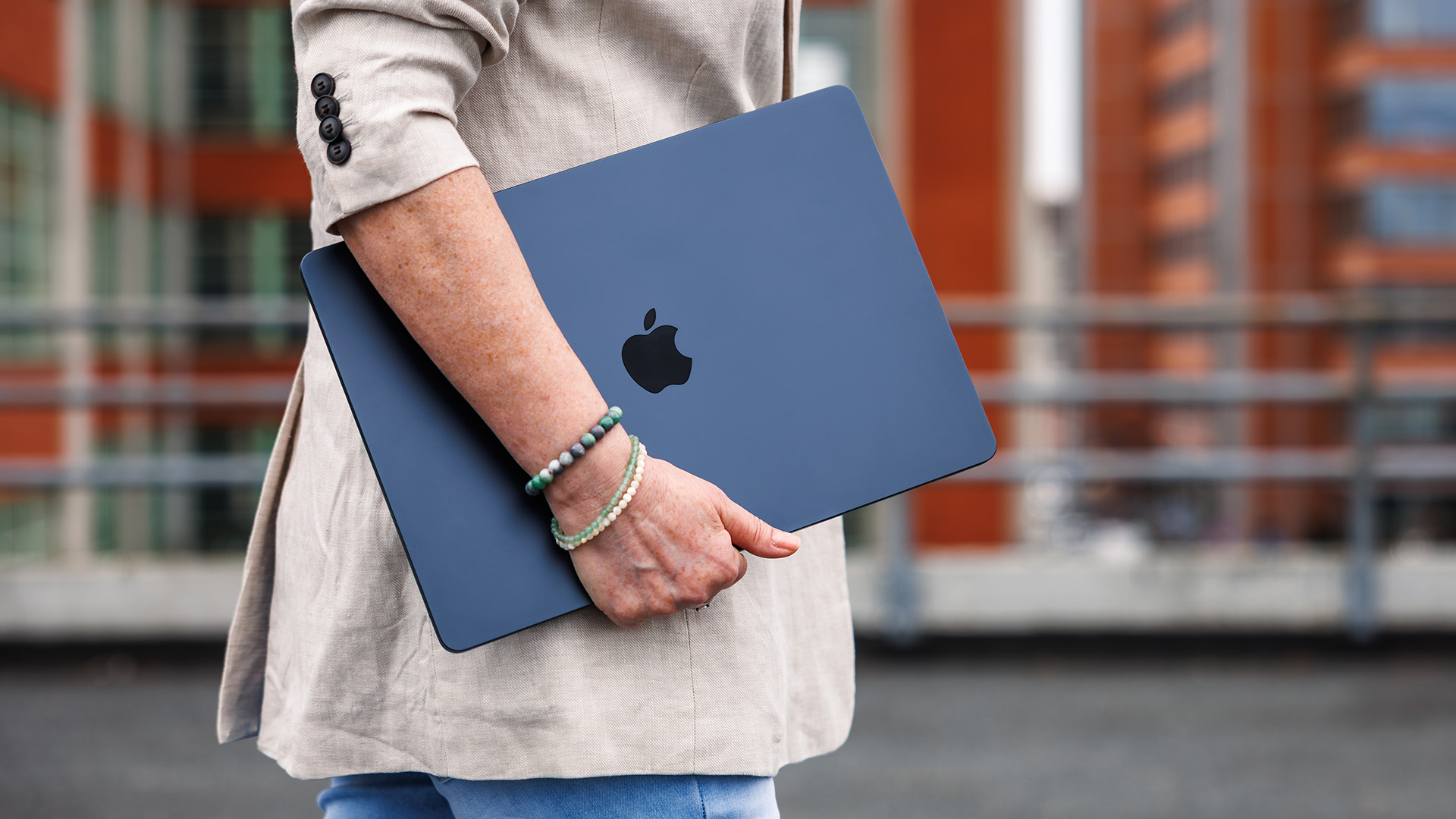 Woman carrying MacBook Air down street