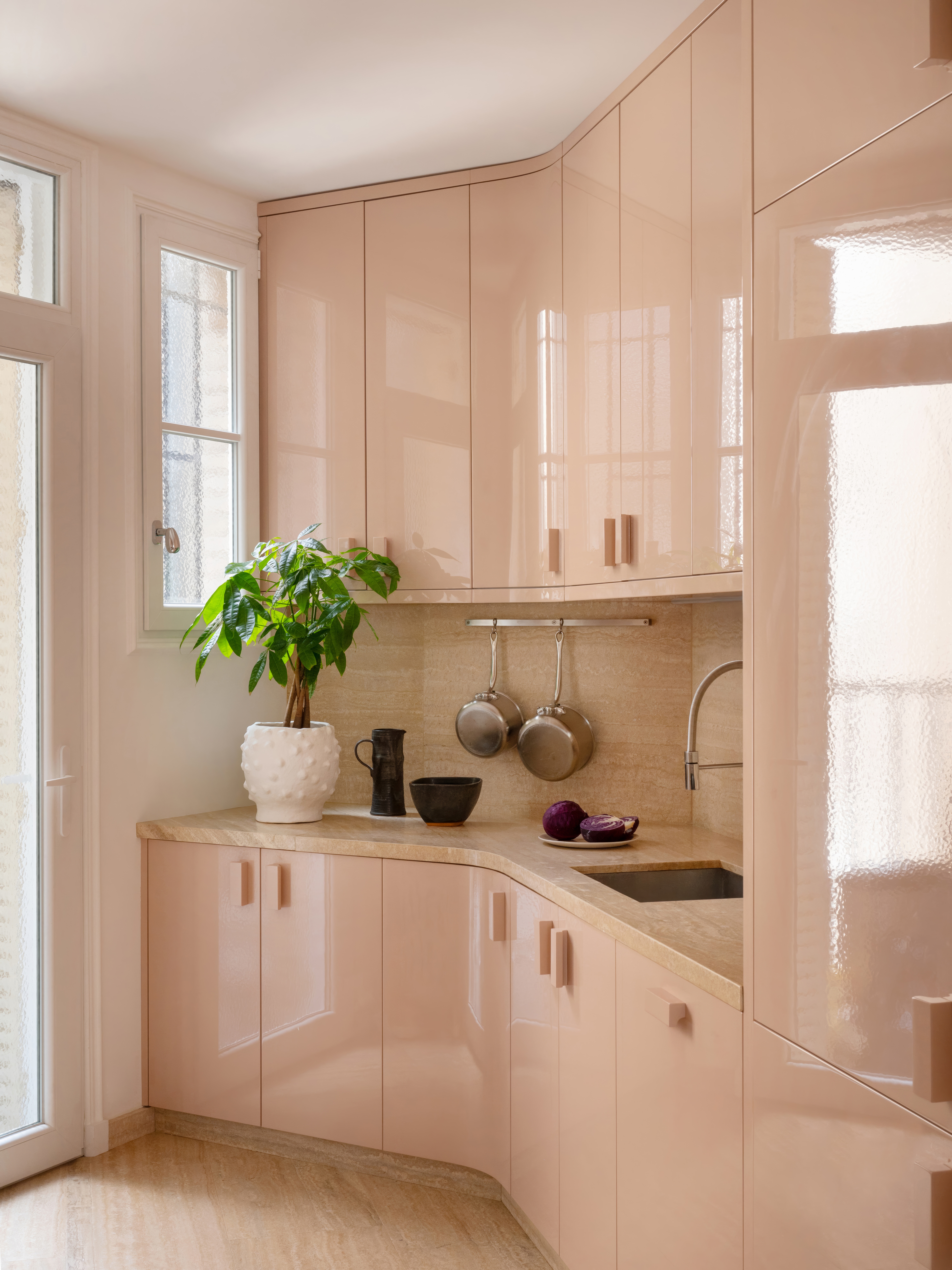 A small kitchen designed in an awkward layout with pink lacquer finish