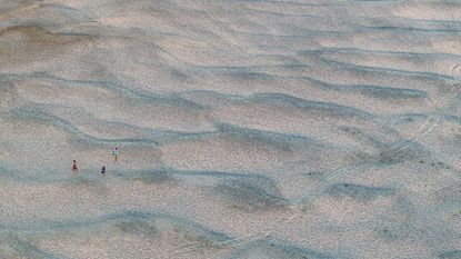 People cross newly exposed sandbanks on the Danube River as water levels fall during prolonged dry conditions in Apatin, Serbia